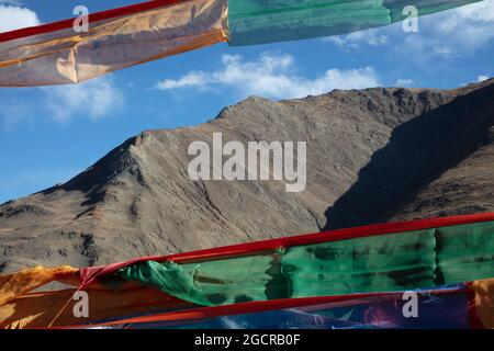 Bandiere di preghiera di fronte alle montagne dell'Himalaya. Il meraviglioso paesaggio del Tibet. Bandiere di preghiera colorate sotto il cielo blu e nuvole bianche nel Foto Stock