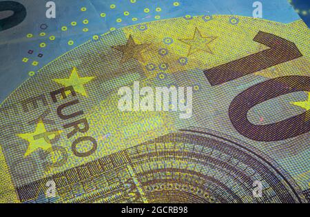 Banconota da dieci Euro sotto luce UV fluorescente. Immagine macro in primo piano del denaro europeo illuminata con luce Fluor. Carta moneta del centro europeo Foto Stock