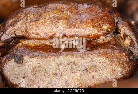 Primo piano di un caffè in grani. Fotografia macro-panoramica di chicchi di caffè ad alta risoluzione. Ultracompatto dettagliato su un caffè tostato. Microscopico Foto Stock