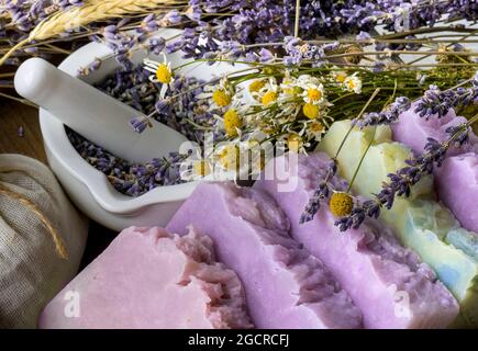 Sapone fatto a mano con fiori ed erbe essiccati di lavanda e camomilla. Foto Stock