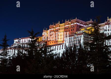 Lhasa, capitale del Tibet. Il Palazzo Potala illuminato a Lhasa, Tibet, Cina. Una lunga esposizione a Chengguan, sul lato della strada con vi Foto Stock