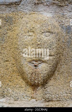 Llivia, Spagna. 2 agosto 2021. Faccia scolpita su pietra di granito nella chiesa di nostra Signora degli Angeli. Tempio romanico e gotico. Foto Stock