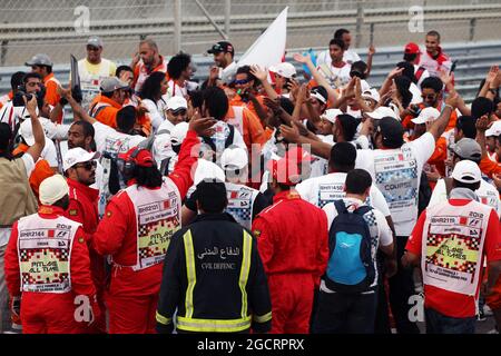 I marshal festeggiano alla fine della gara. Gran Premio del Bahrain, domenica 22 aprile 2012. Sakhir, Bahrein. Foto Stock