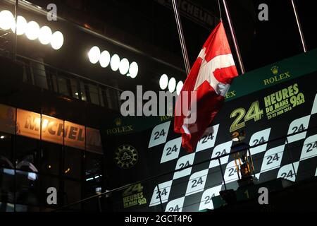 Il podio vola la bandiera danese a metà albero come tributo ad Allan Simonsen (DEN) Aston Martin Vantage V8, che ha subito un incidente mortale in gara. Le Mans 24 ore di gara, sabato 22 giugno 2013. Le Mans, Francia. Foto Stock