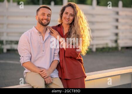 Felice giovane coppia in casualwear godendo di una giornata di sole in campagna Foto Stock