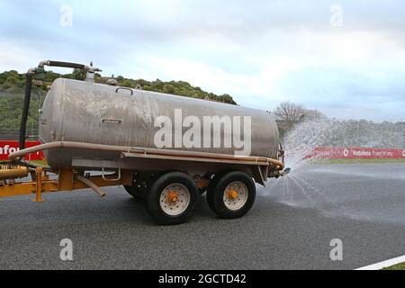 Il trattore irrigatore setta la pista mentre la giornata viene dichiarata la giornata ufficiale delle prove sugli pneumatici Pirelli. Test di Formula uno, giorno due, mercoledì 29 gennaio 2014. Jerez, Spagna. Foto Stock