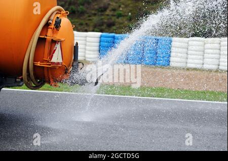 Il trattore irrigatore setta la pista mentre la giornata viene dichiarata la giornata ufficiale delle prove sugli pneumatici Pirelli. Test di Formula uno, giorno due, mercoledì 29 gennaio 2014. Jerez, Spagna. Foto Stock