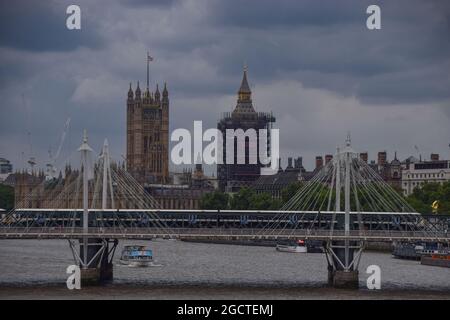 Le nuvole scure si radunano sui ponti Houses of Parliament, Big ben e Hungerford e Golden Jubilee. Londra, Regno Unito. 5 agosto 202 Foto Stock