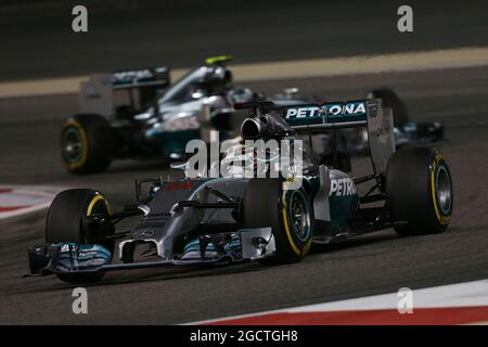 Lewis Hamilton (GBR) Mercedes AMG F1 W05 guida Nico Rosberg (GER) Mercedes AMG F1 W05. Gran Premio del Bahrain, domenica 6 aprile 2014. Sakhir, Bahrein. Foto Stock