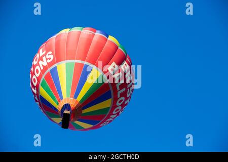 Una mongolfiera Bristol Balloons passa sopra Ashton Court Estate, Bristol, su un cielo blu. Foto Stock