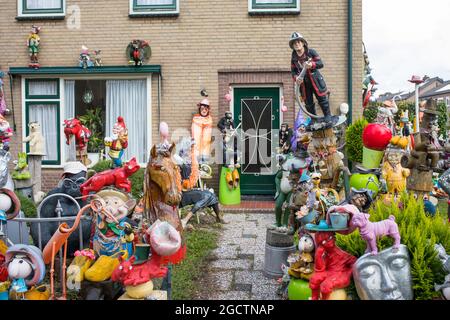 Casa residenziale con un'abbondante collezione di decorazioni e sculture nel giardino anteriore. Foto Stock