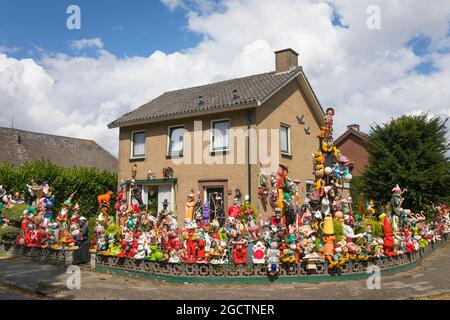 Casa residenziale con un'abbondante collezione di decorazioni e sculture nel giardino anteriore. Foto Stock