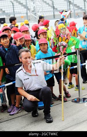 Sam Michael (AUS) McLaren Direttore Sporting con giovani tifosi ai box. Gran Premio del Giappone, giovedì 2 ottobre 2014. Suzuka, Giappone. Foto Stock