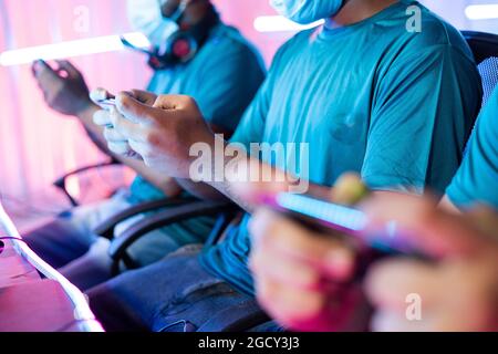 Primo piano di gioco a mano del giocatore che gioca il video gioco sul telefono cellulare alla partita di torneo di eSport live Foto Stock