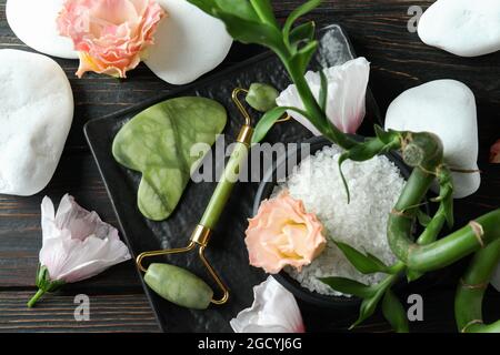 Concetto di cura della pelle con rullo facciale su tavolo di legno Foto Stock