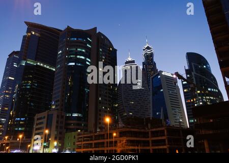 Fotografia notturna dell'edificio Exchange e di altre torri illuminate a Dubai, Emirati Arabi Uniti Foto Stock