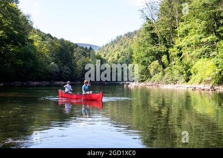 Madre e figlio guidano una canoa sul fiume Kolpa al confine tra Slovenia e Croazia Foto Stock