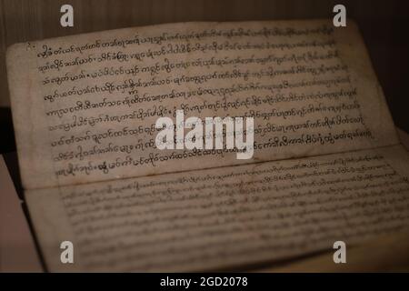 Pagine di un antico libro con testo scritto a mano, probabilmente in lingua vecchia Khmer, in un'esposizione in uno dei musei della Thailandia Foto Stock