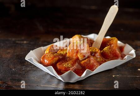Appetitosi pezzi di salsiccia di maiale fritta con ketchup al curry Foto Stock