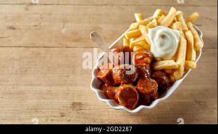 Da sopra di gustosi pezzi di salsiccia curry con patatine calde Foto Stock
