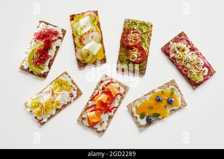 Dall'alto si servono toast assortiti di pane croccante con frutta fresca e verdure Foto Stock