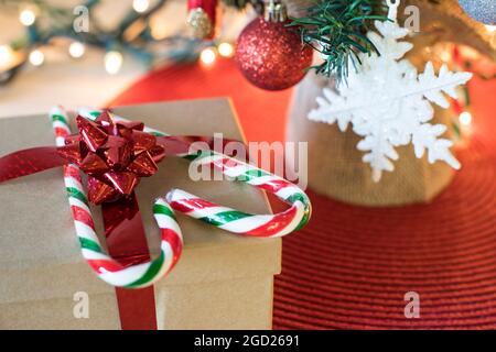 Decorazioni dell'albero di Natale sul tavolo. Concetto di preparazione per Natale e Capodanno. Albero di Natale con scatola regalo e caramelle a forma di cuore. Foto Stock