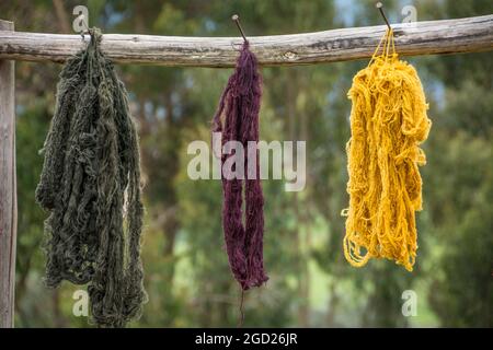 Filato di alpaca tinto naturalmente per tessitura di tessuti appesi ad asciugare; Misminay Village, Sacred Valley, Peru. Foto Stock