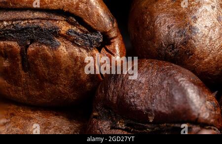 Primo piano di un caffè in grani. Fotografia macro-panoramica di chicchi di caffè ad alta risoluzione. Ultracompatto dettagliato su un caffè tostato. Microscopico Foto Stock
