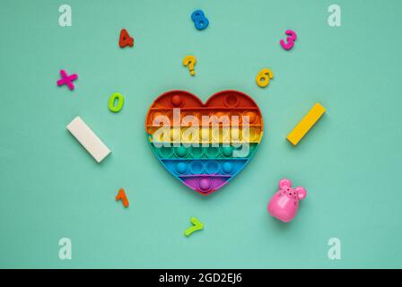 Pop it colorato arcobaleno a forma di cuore giocattolo antistress per i bambini. Foto Stock