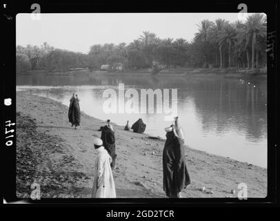 Iraq. Scene fluviali sull'Eufrate prese a Hilla. Donne che trasportano acqua dal fiume ca. 1932 Foto Stock