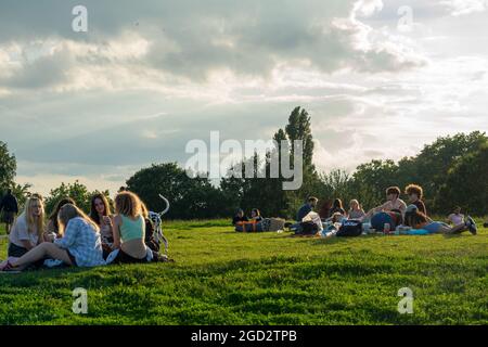 Londra, 10th agosto 2021. UK Weather: Una vista calda e chiara del tramonto su Londra con i giovani che si riuniscono su Parliament Hill, Hampstead Heath, al tramonto il giorno di Un livello risultati nel 2021. Foto Stock