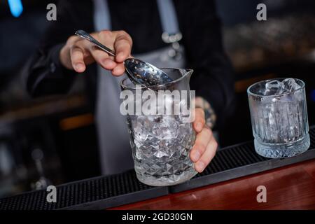 Il barista maschile professionista crea un cocktail alcolico Foto Stock