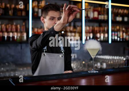 il barman sta facendo un cocktail con una bolla d'aria fumosa Foto Stock