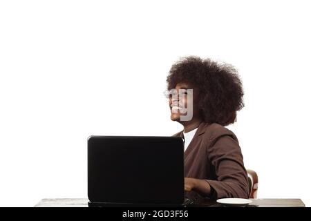 Giovane donna insignita di affari Ispanica Latina nera, con i capelli afro, sorride nel suo ufficio su sfondo bianco Foto Stock