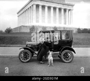 Ford Motor Company, berlina, uomo che apre la porta per una donna e il suo cane ca. Tra il 1910 e il 1925 Foto Stock