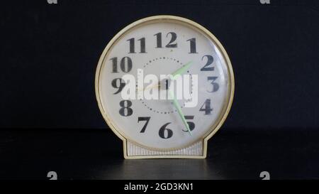 Un vecchio orologio di allarme su sfondo nero Foto Stock