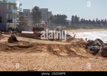 Collaroy Beach Sydney, gli escavatori che lavorano sulla creazione di protezione contro l'erosione della spiaggia nel 2021 a seguito dei danni provocati dalla tempesta alle proprietà nel giugno 2016, Sydney Foto Stock