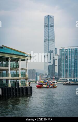 La 'Night Star', una delle flotte di Star Ferry, passa gli uomini che pescano dal Molo centrale dei traghetti 8 sull'isola di Hong Kong, di fronte all'ICC a West Kowloon Foto Stock