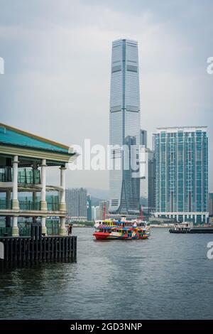 La 'Night Star', una delle flotte di Star Ferry, passa gli uomini che pescano dal Molo centrale dei traghetti 8 sull'isola di Hong Kong, di fronte all'ICC a West Kowloon Foto Stock