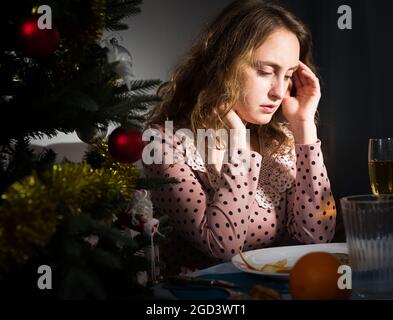 La ragazza si annoia e bevendo champagne nel nuovo anno vicina Foto Stock