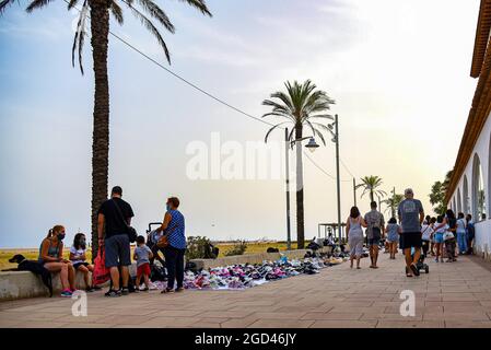 Vendrell, Spagna. 05 agosto 2021. La gente cammina di fronte ai prodotti  illegali venduti dai venditori di strada a Vendrell. I venditori illegali  di strada conosciuti come 'Mantero' o 'Top Manta', principalmente