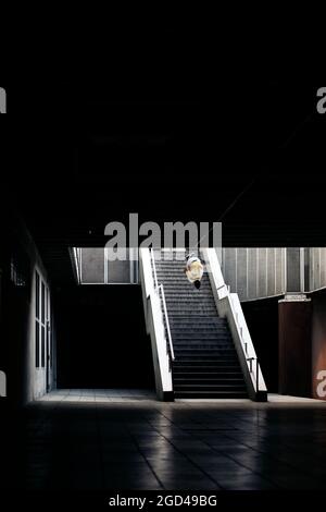 Giovane e simpatico che fa incredibili trucchi da parkour in città e si diverte. Foto Stock