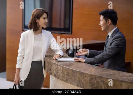 La receptionist dell'hotel parla con il cliente Foto Stock