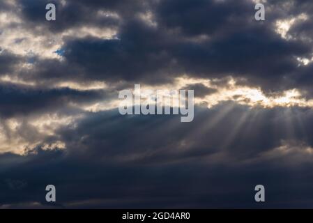 Raggi di luce che brillano attraverso nuvole scure.bello cielo drammatico con raggi di sole.raggi di sole drammatici del cielo. Foto Stock