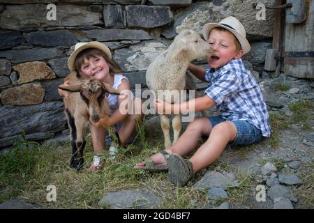 FRANCIA, SAVOIE (SAVOIA) (73 ) SAN MARTINO DI BELLEVILLE, BAMBINO E AGNELLI NELLA FATTORIA DELL'ALTA MONTAGNA PASCOLO DELLA CACCIA Foto Stock
