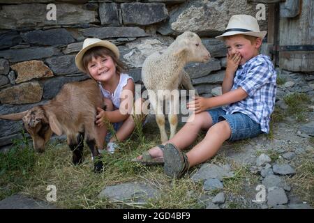 FRANCIA, SAVOIE (SAVOIA) (73 ) SAN MARTINO DI BELLEVILLE, BAMBINO E AGNELLI NELLA FATTORIA DELL'ALTA MONTAGNA PASCOLO DELLA CACCIA Foto Stock