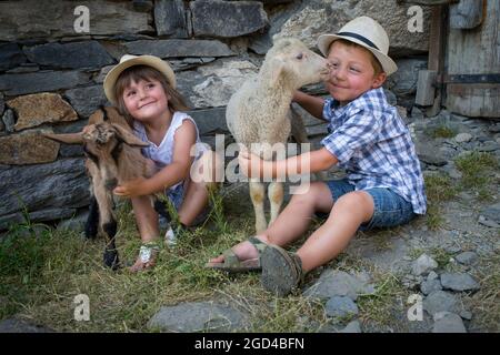 FRANCIA, SAVOIE (SAVOIA) (73 ) SAN MARTINO DI BELLEVILLE, BAMBINO E AGNELLI NELLA FATTORIA DELL'ALTA MONTAGNA PASCOLO DELLA CACCIA Foto Stock