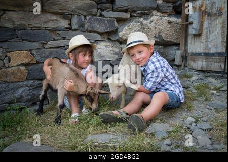 FRANCIA, SAVOIE (SAVOIA) (73 ) SAN MARTINO DI BELLEVILLE, BAMBINO E AGNELLI NELLA FATTORIA DELL'ALTA MONTAGNA PASCOLO DELLA CACCIA Foto Stock
