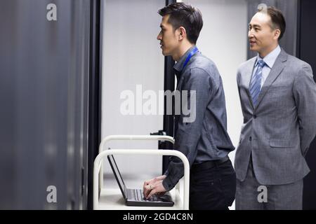 Tecnici che eseguono la manutenzione nella sala computer Foto Stock