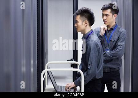 Tecnici che eseguono la manutenzione nella sala computer Foto Stock